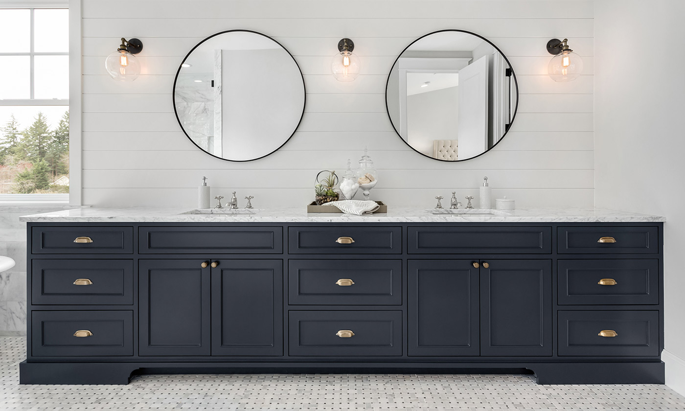 Navy blue bathroom cabinets with two sinks and two mirrors